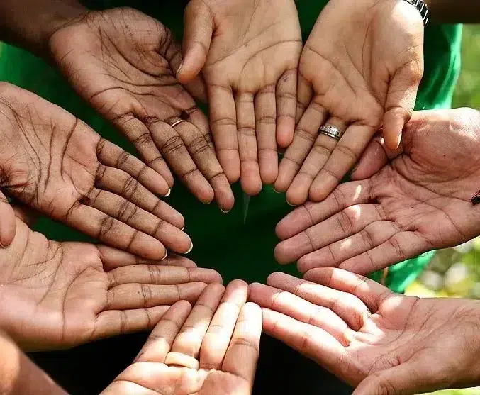 A circle of hands from diverse individuals symbolizing unity, collaboration, and Vanilla Fair’s commitment to ESG (Environmental, Social, and Governance) values.